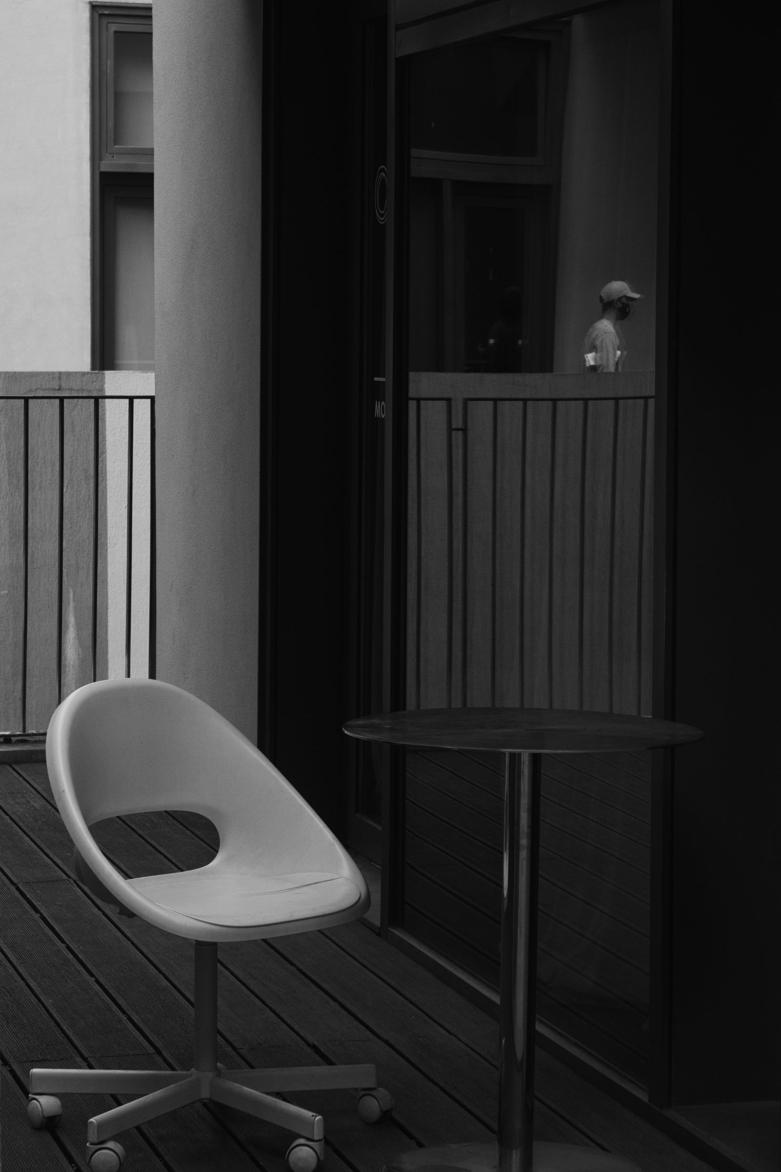 A chair beside a small patio table in black and white