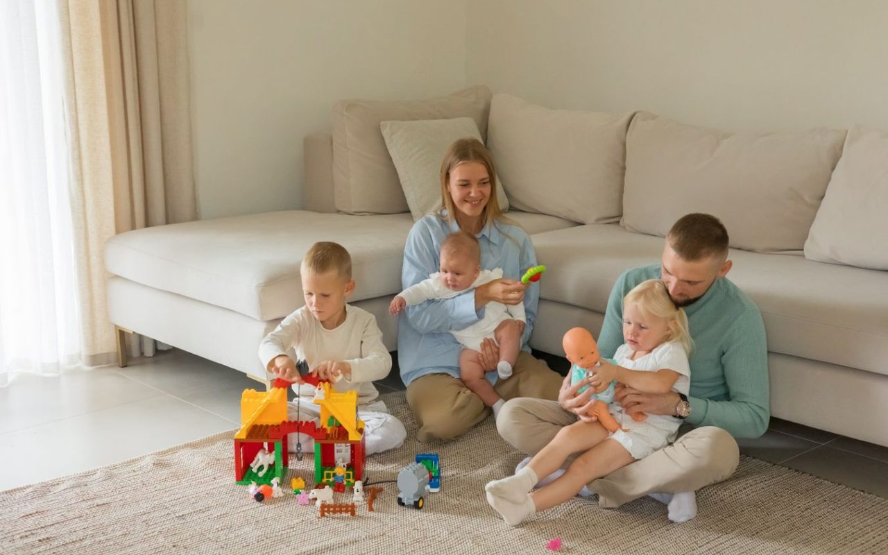 Family playing with toys in a modern living room, showing how play can share space with everyday living