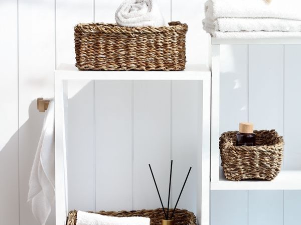 Minimal bathroom shelving with woven baskets showing practical contained storage