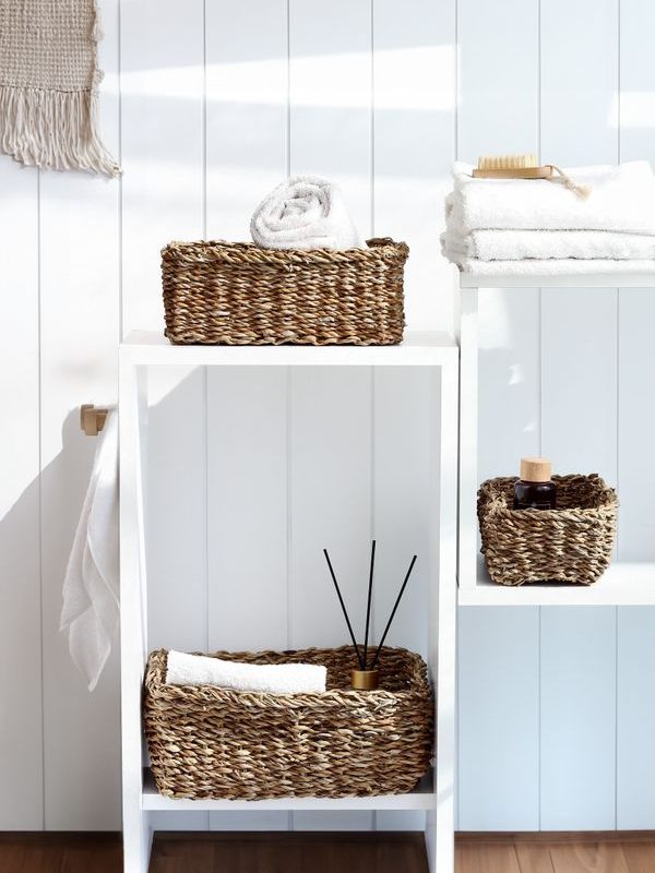 Minimal bathroom shelving with woven baskets showing practical contained storage