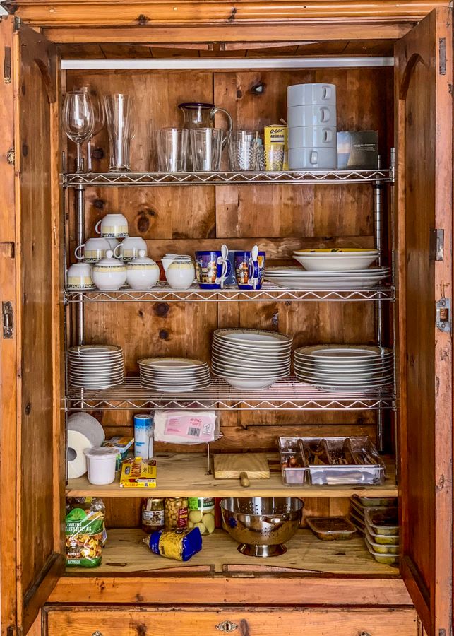 Deep kitchen cabinet filled with dishes, glassware, and pantry items showing how visibility matters