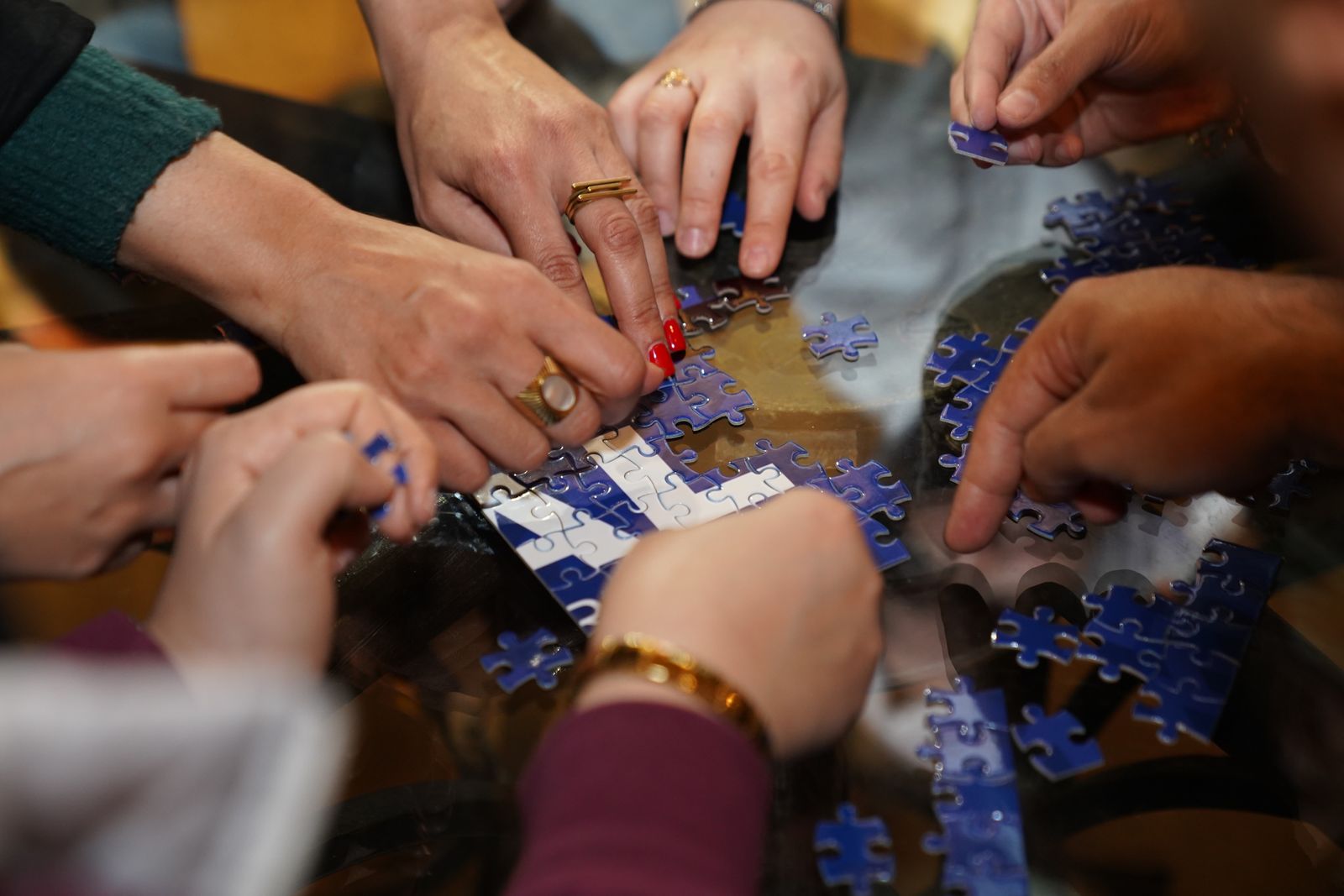 Several people assembling a jigsaw puzzle together