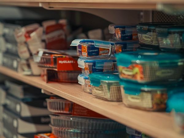 Organized kitchen pantry shelves with storage containers and clearly visible categories