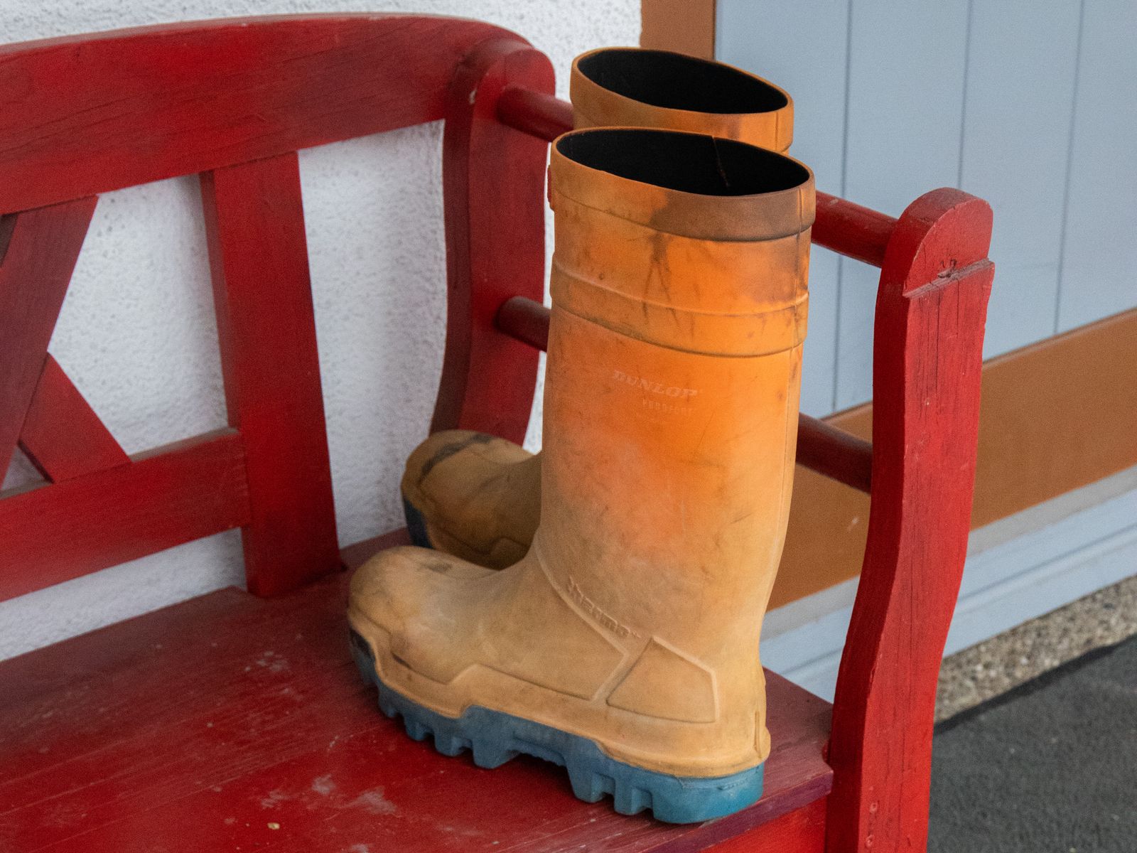 Orange rubber rain boots near a doorway