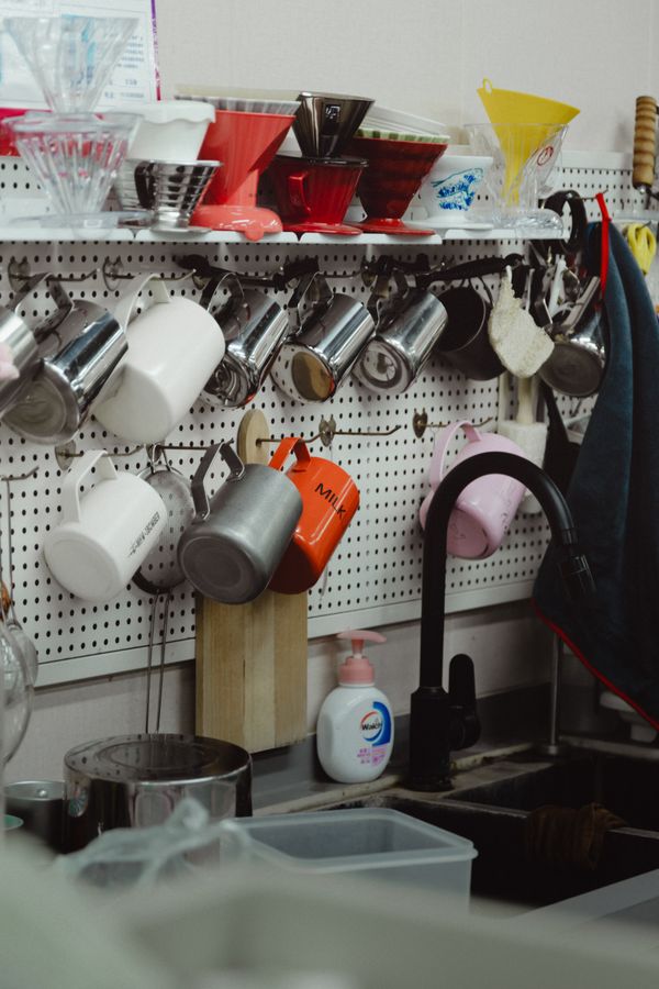 Organized compact kitchen with mugs, tools, and shelves around a limited counter area