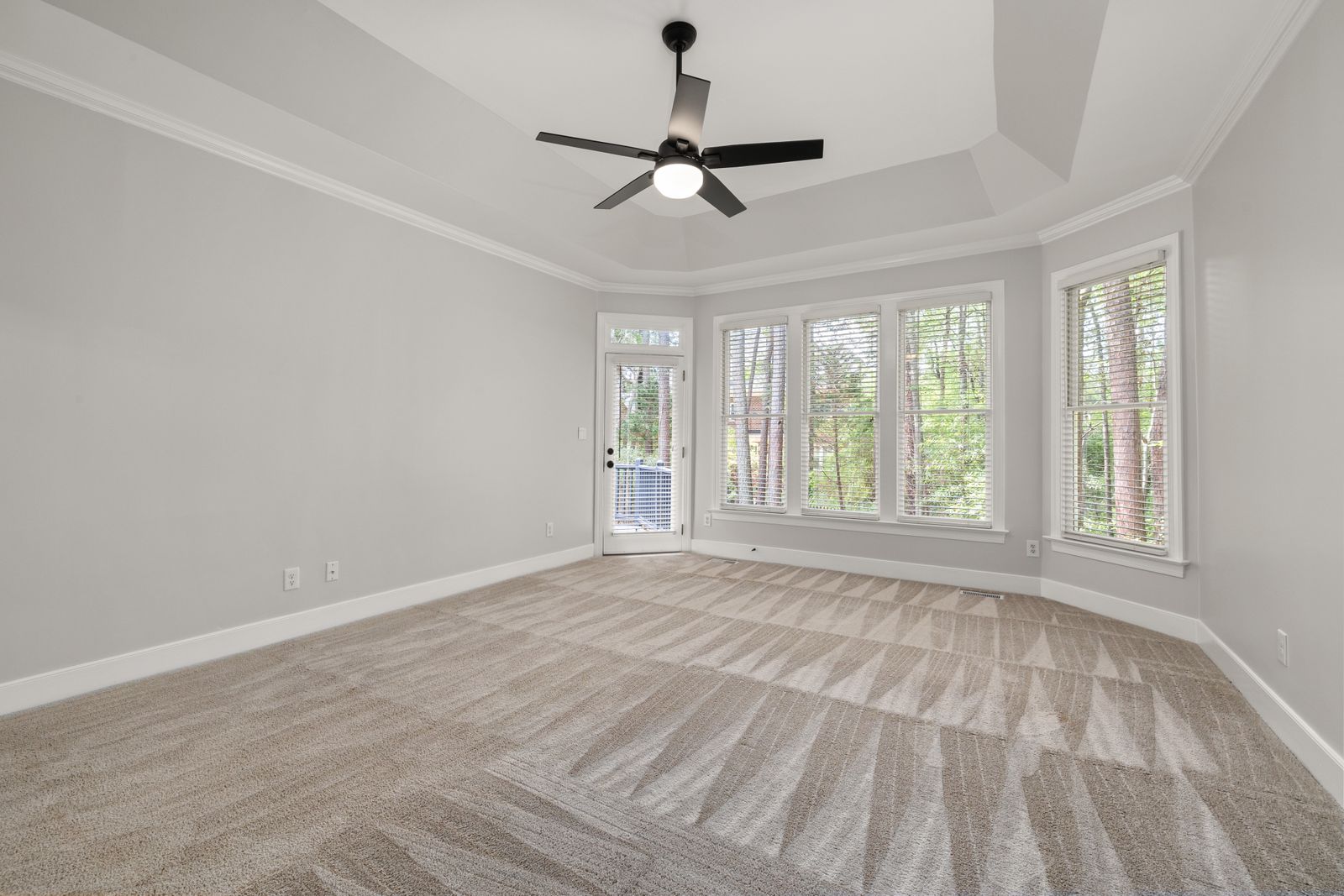 Bright room with large windows and fan