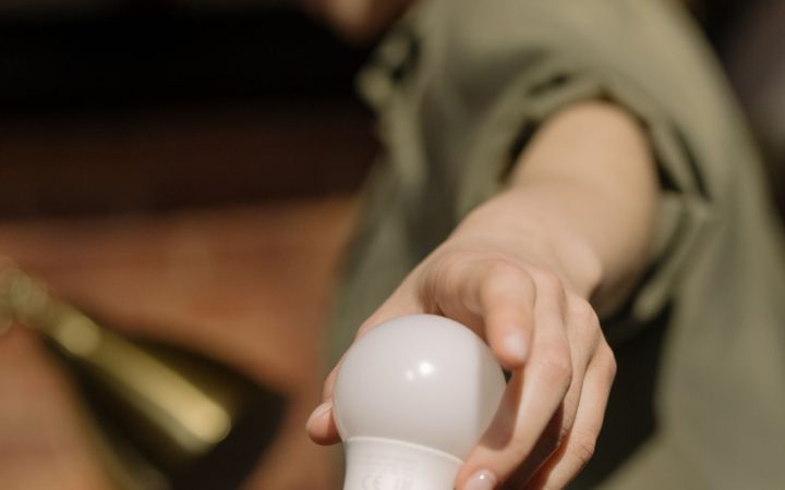 Person changing a light bulb indoors
