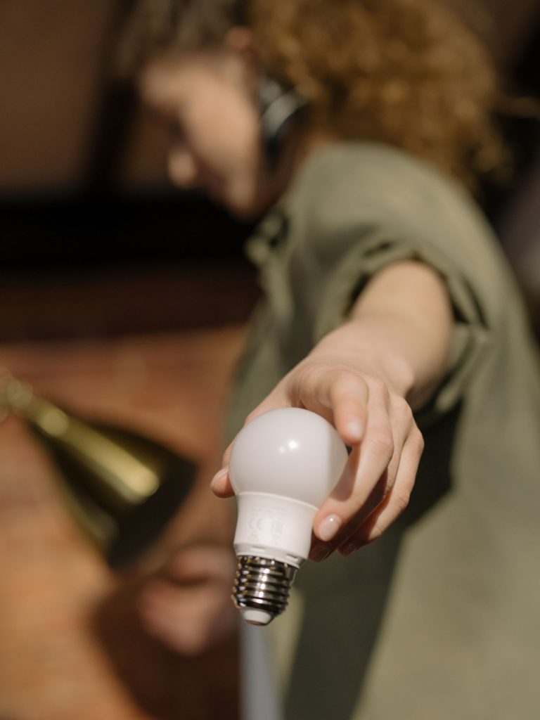 Person changing a light bulb indoors