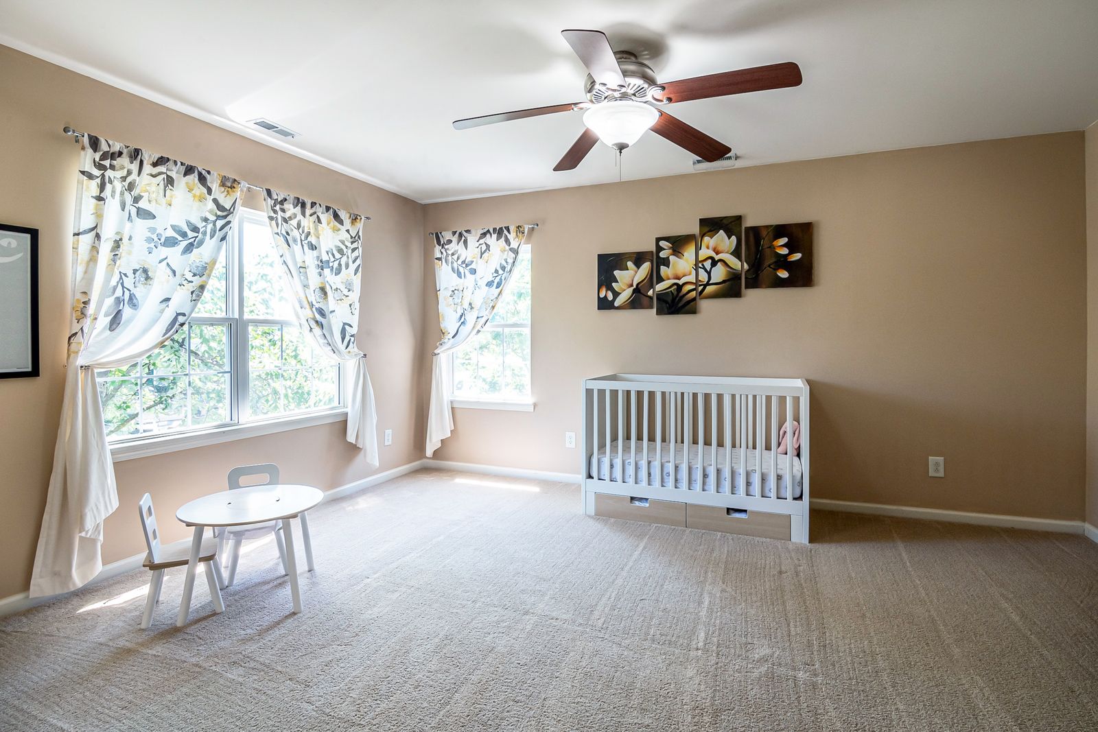 A white crib and furniture in a nursery