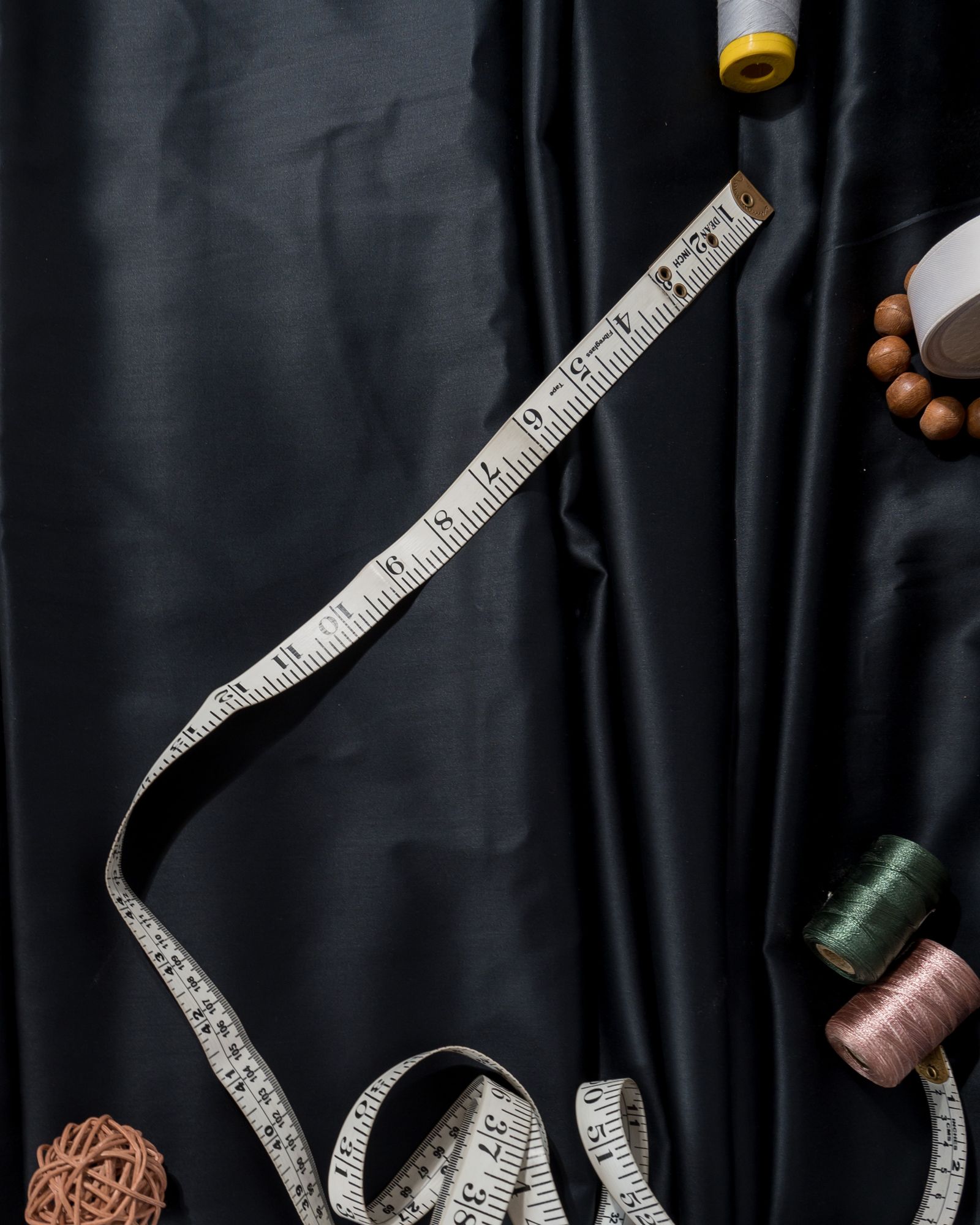 A measuring tape held beside hanging fabric