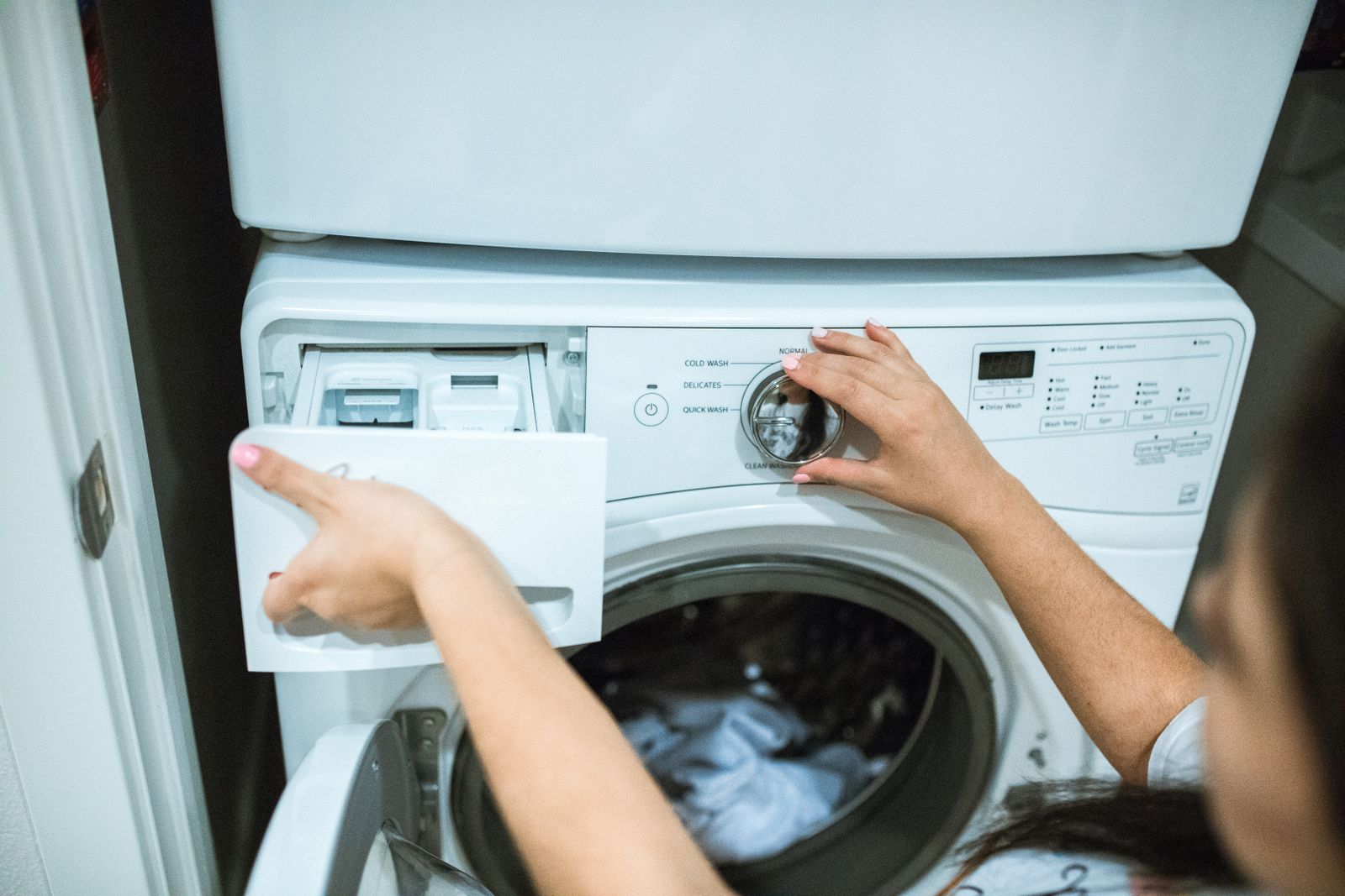 Person adjusting a front-load washing machine