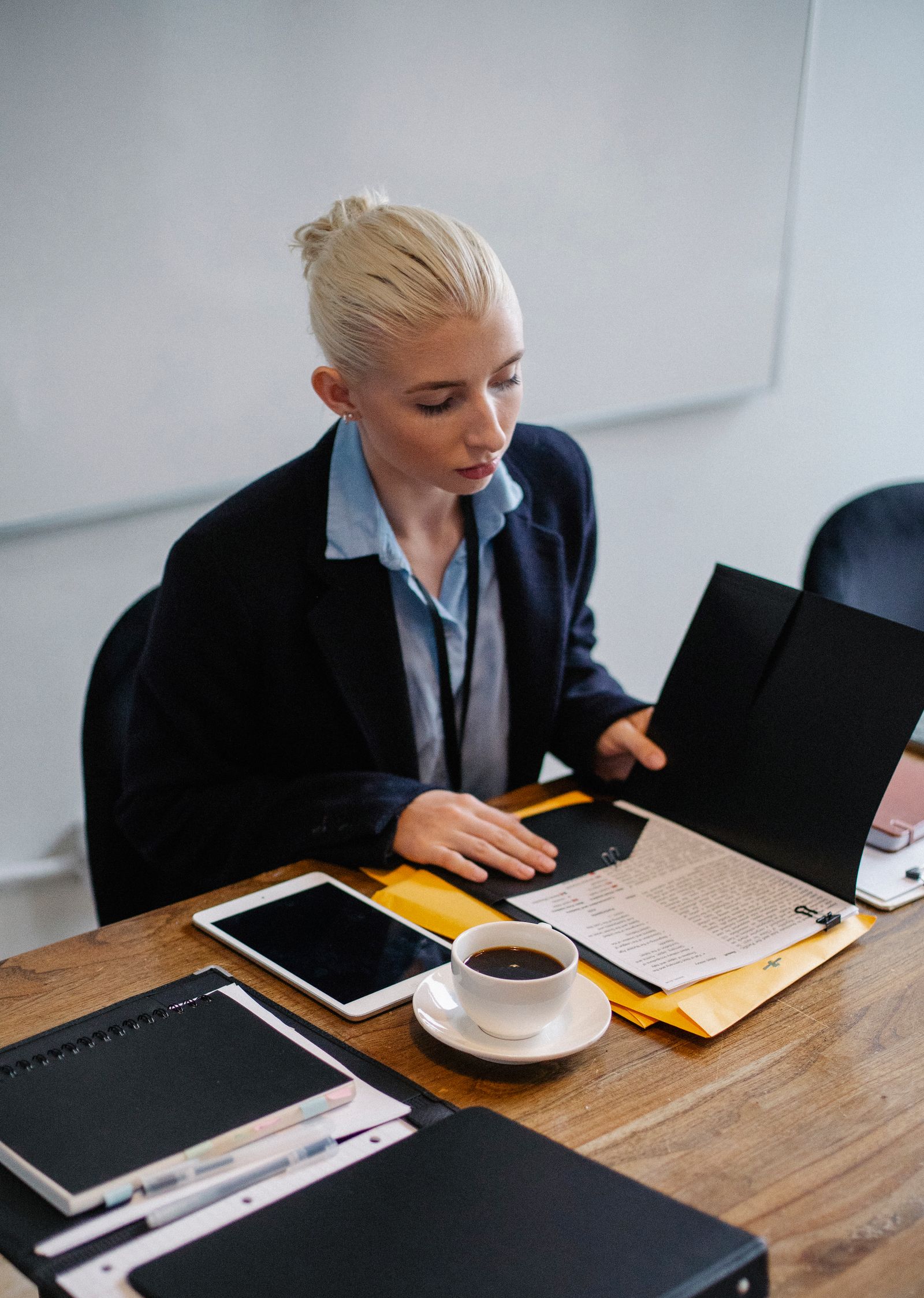 Person reviewing paperwork and folders at a desk