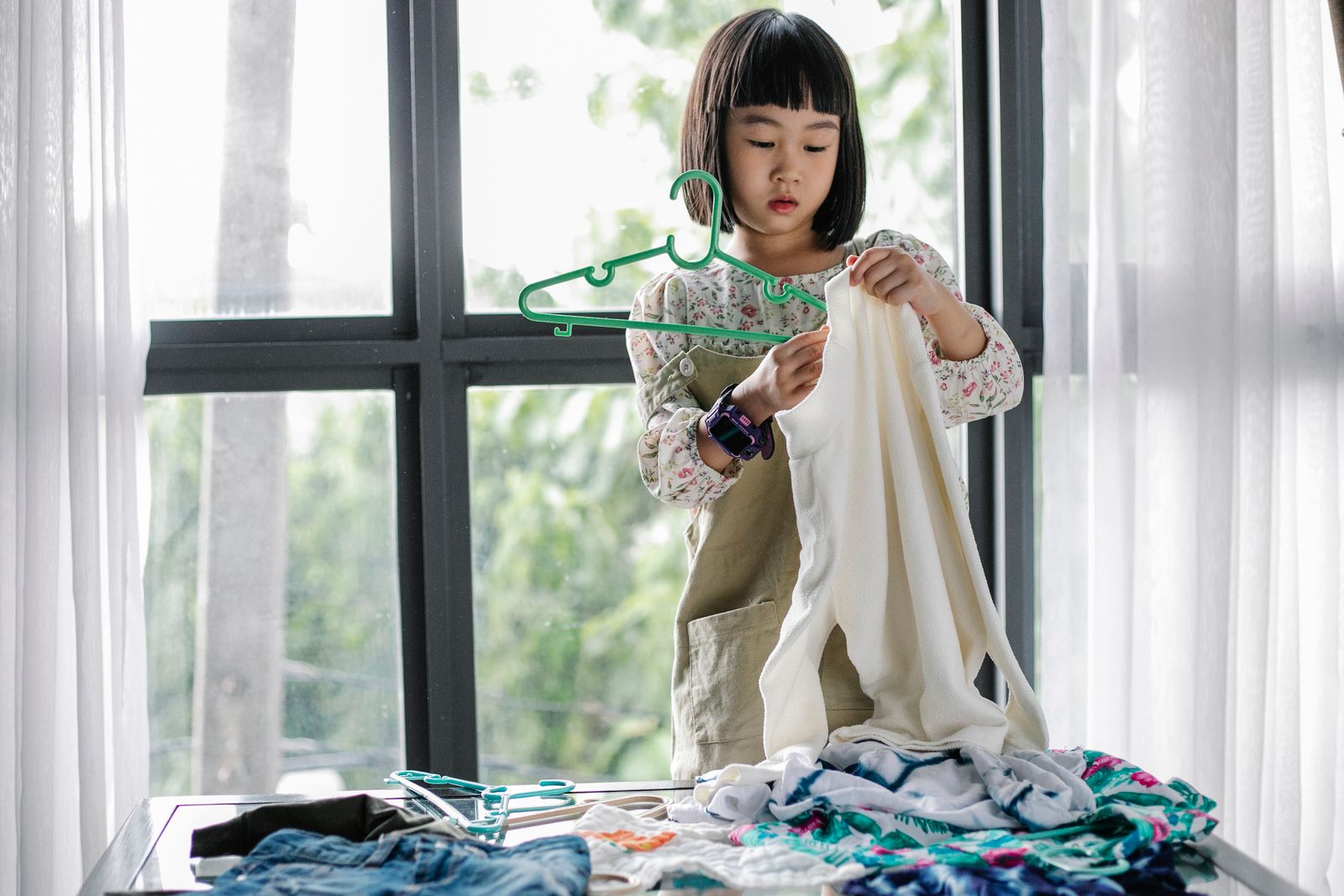 Young girl organizing clothes on hangers