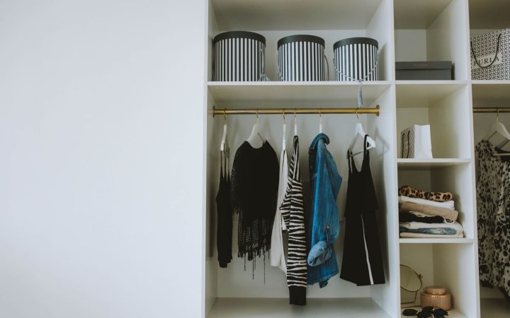 Organized wardrobe with hanging clothes, shelves, and storage boxes illustrating clear shared closet zones