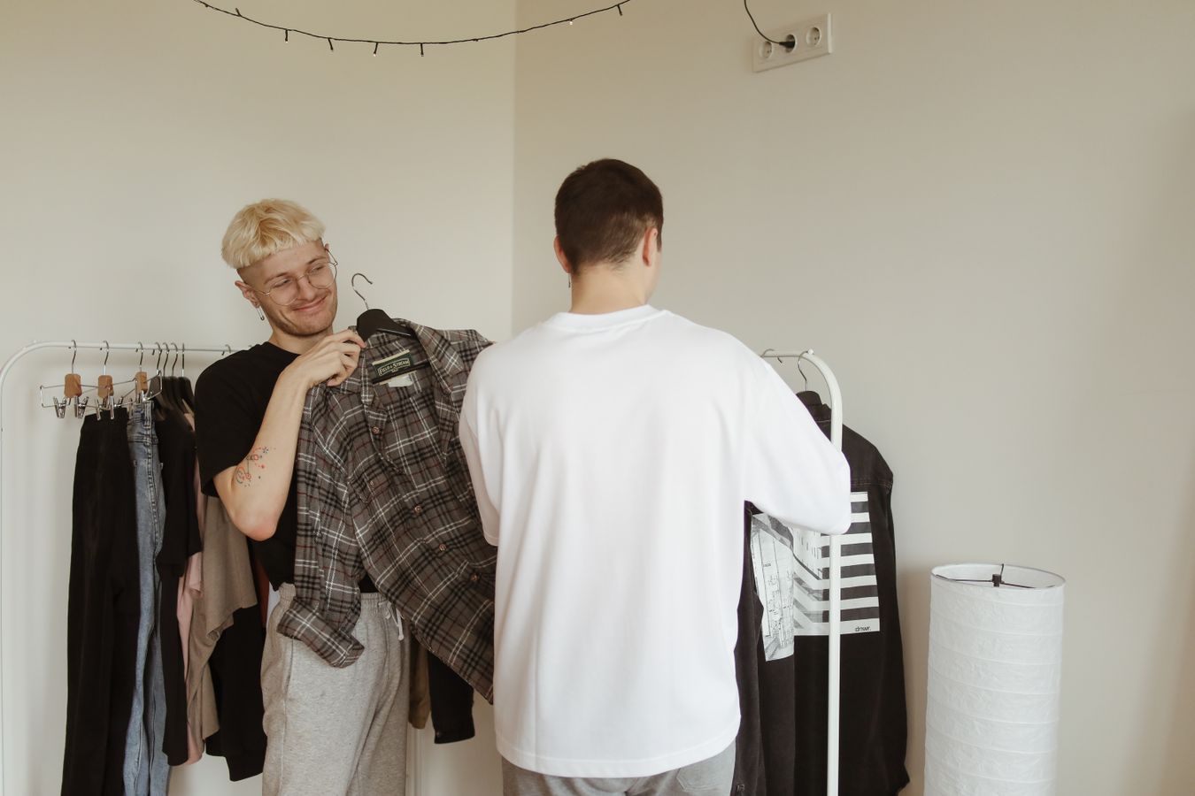 Two adults choosing clothes from one clothing rack, illustrating a shared wardrobe routine