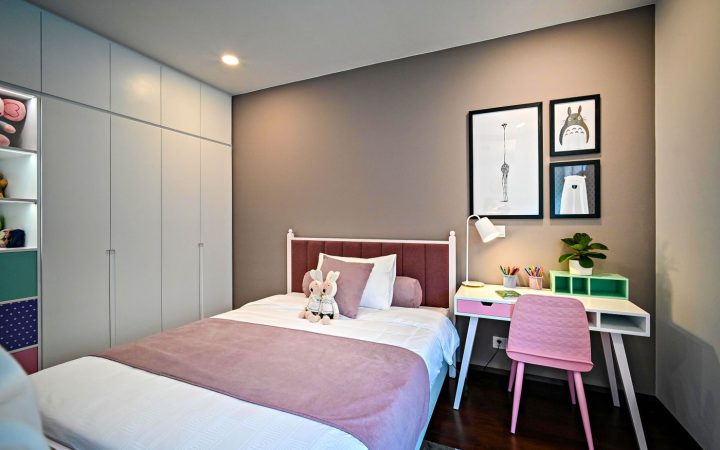 Organized children's bedroom with bed, desk, shelving, and soft decor