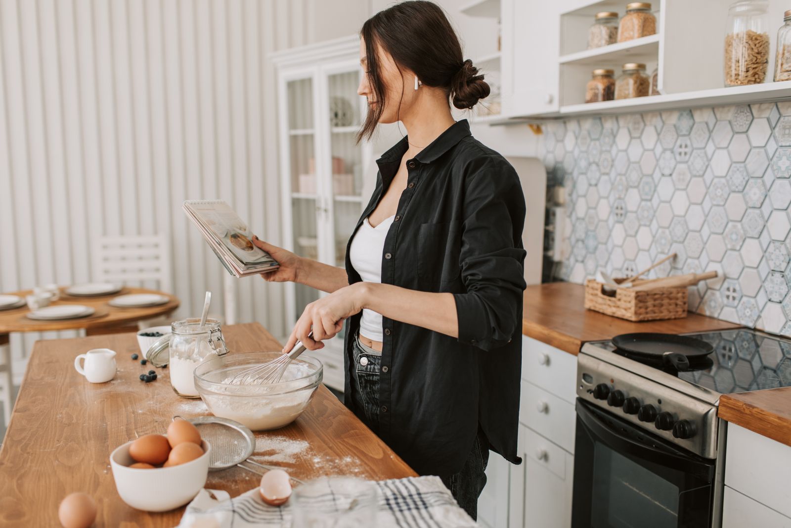 A cook consulting a recipe in a kitchen