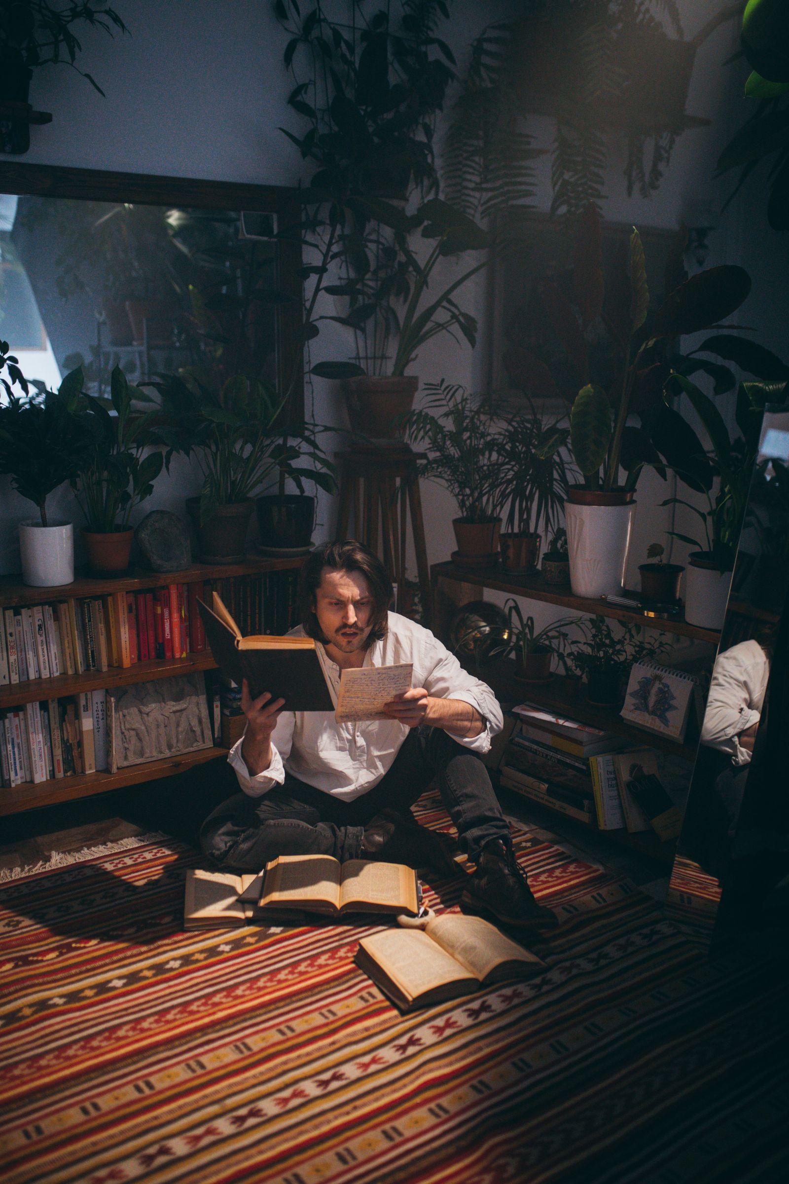 A reader seated among books in a home reading corner