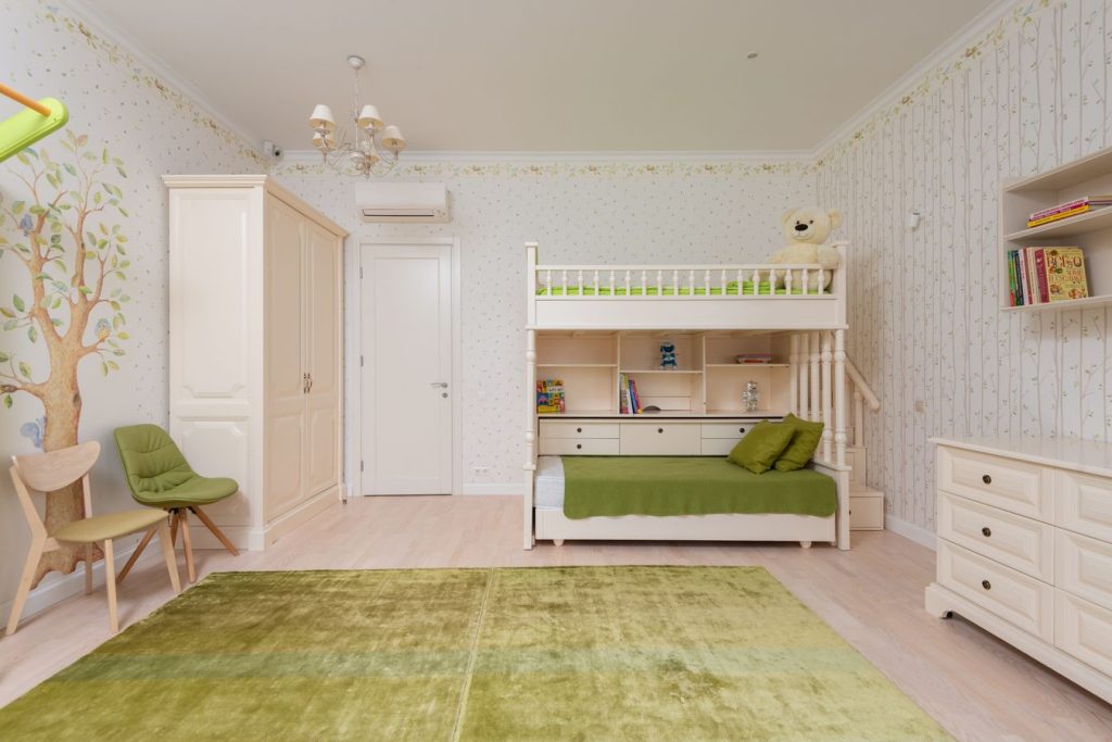 Bright shared children’s bedroom with bunk beds, shelves, and clear floor space