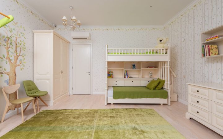Bright shared children’s bedroom with bunk beds, shelves, and clear floor space