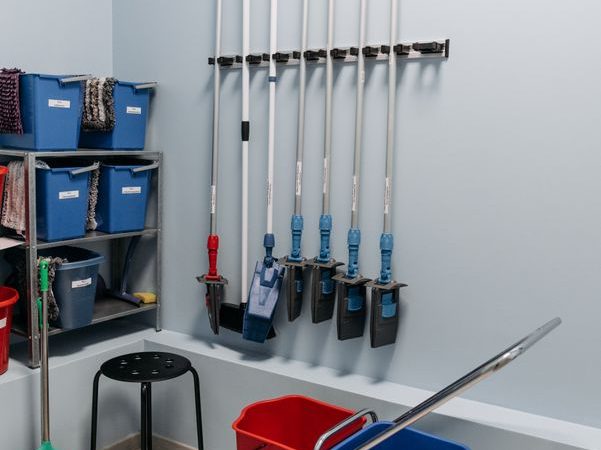 Organized mops, buckets, and cleaning tools stored together in a utility area