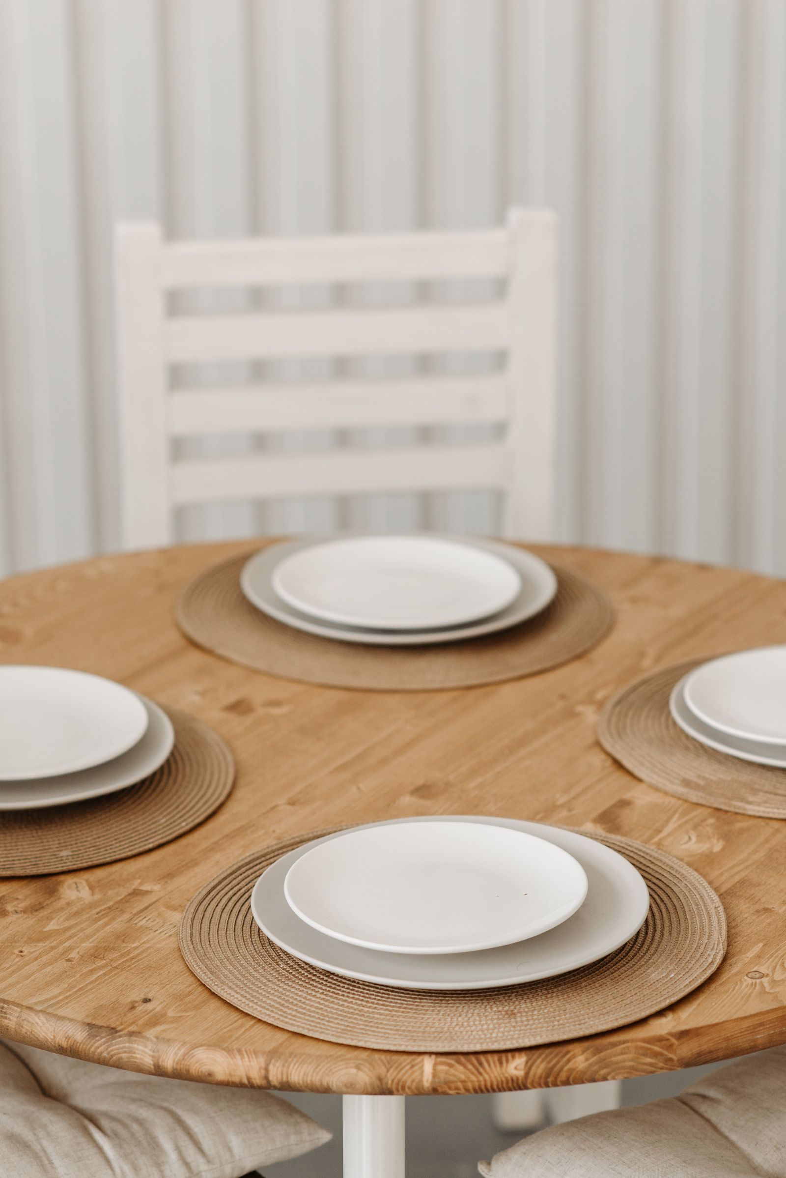 Four white plates on a wooden table