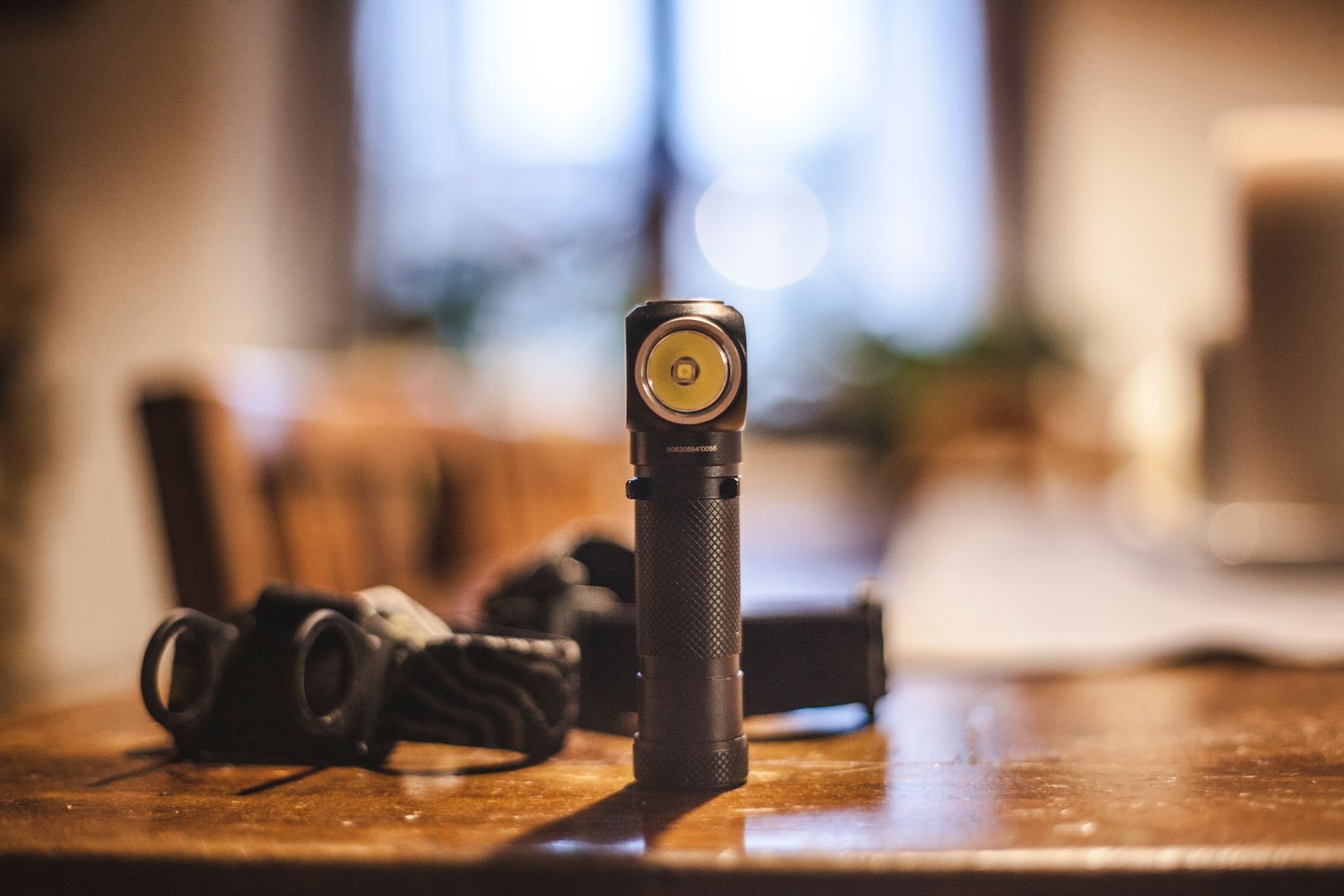 Black flashlight standing on a wooden table