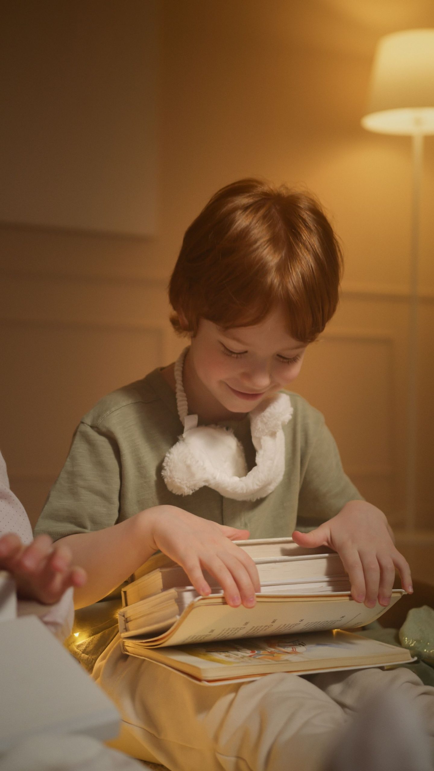 A child reading from a small stack of books