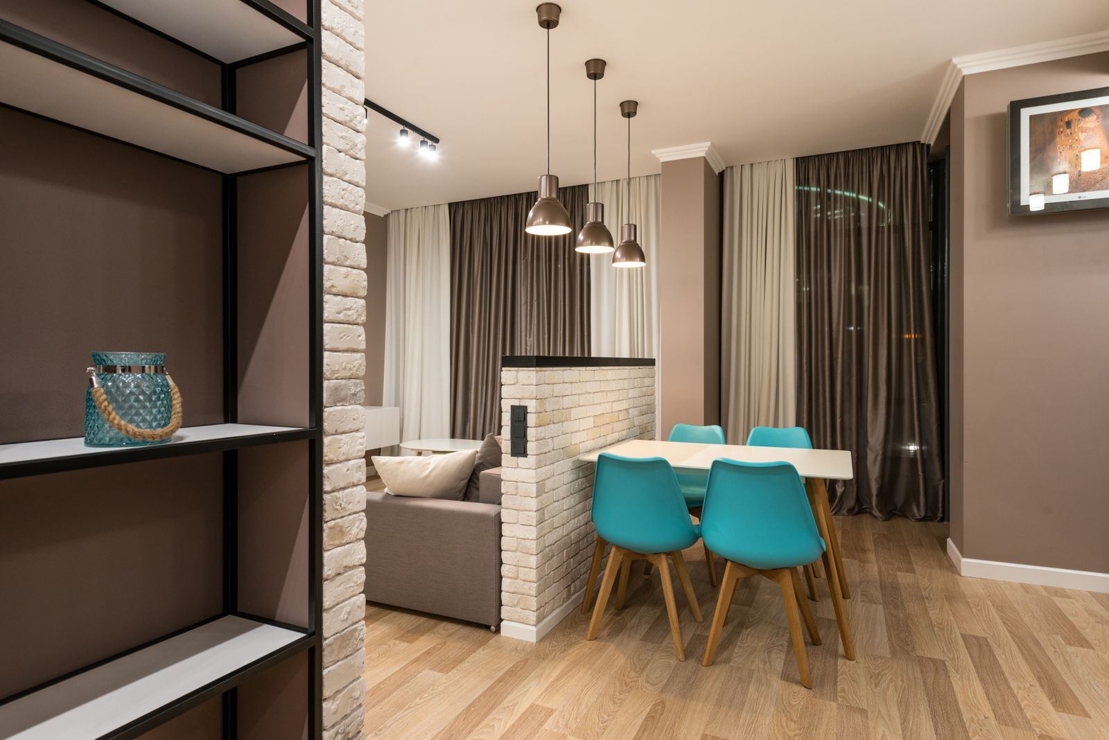 Dining table placed beside a living room in an open-plan apartment