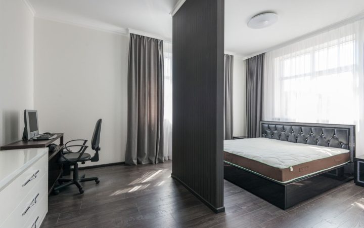 Compact open-plan bedroom with a workspace showing how one small space can support multiple functions