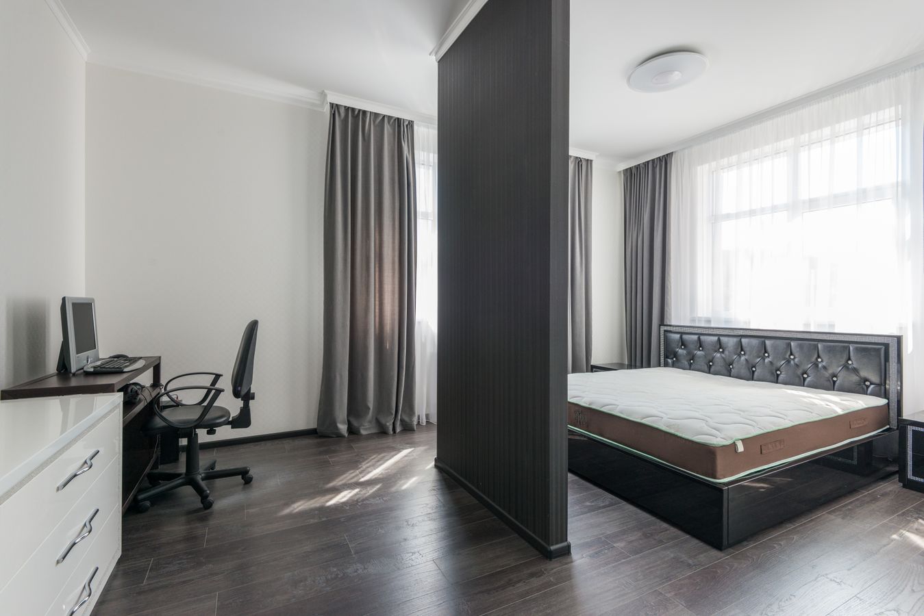 Compact open-plan bedroom with a workspace showing how one small space can support multiple functions