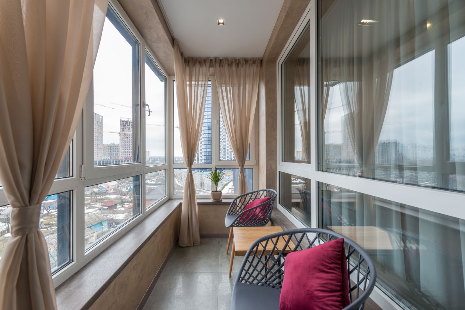 Chairs and a table on an enclosed apartment balcony