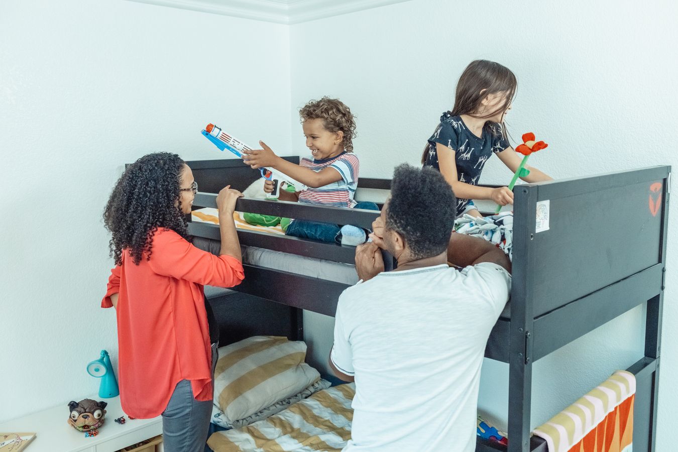 Family in a children’s bedroom with bunk beds and toys, showing accessible shared storage