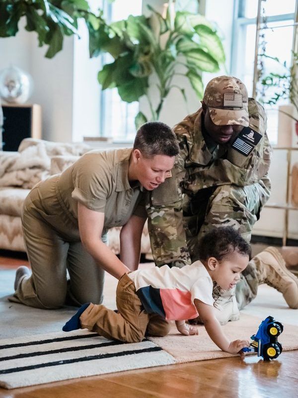 Family with a young child playing in a living room with open floor space around the seating