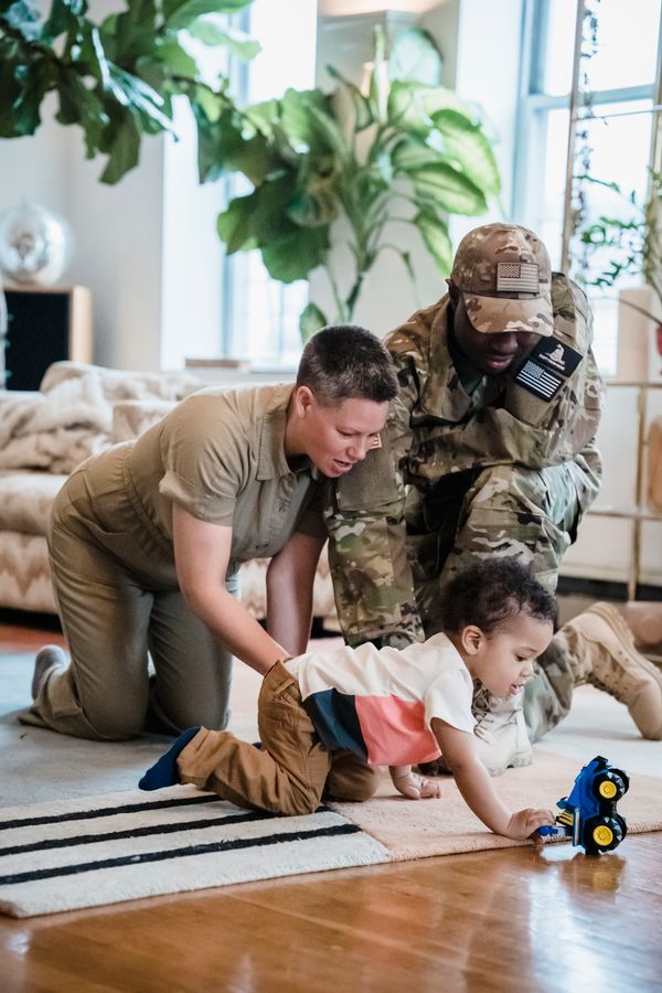 Family with a young child playing in a living room with open floor space around the seating