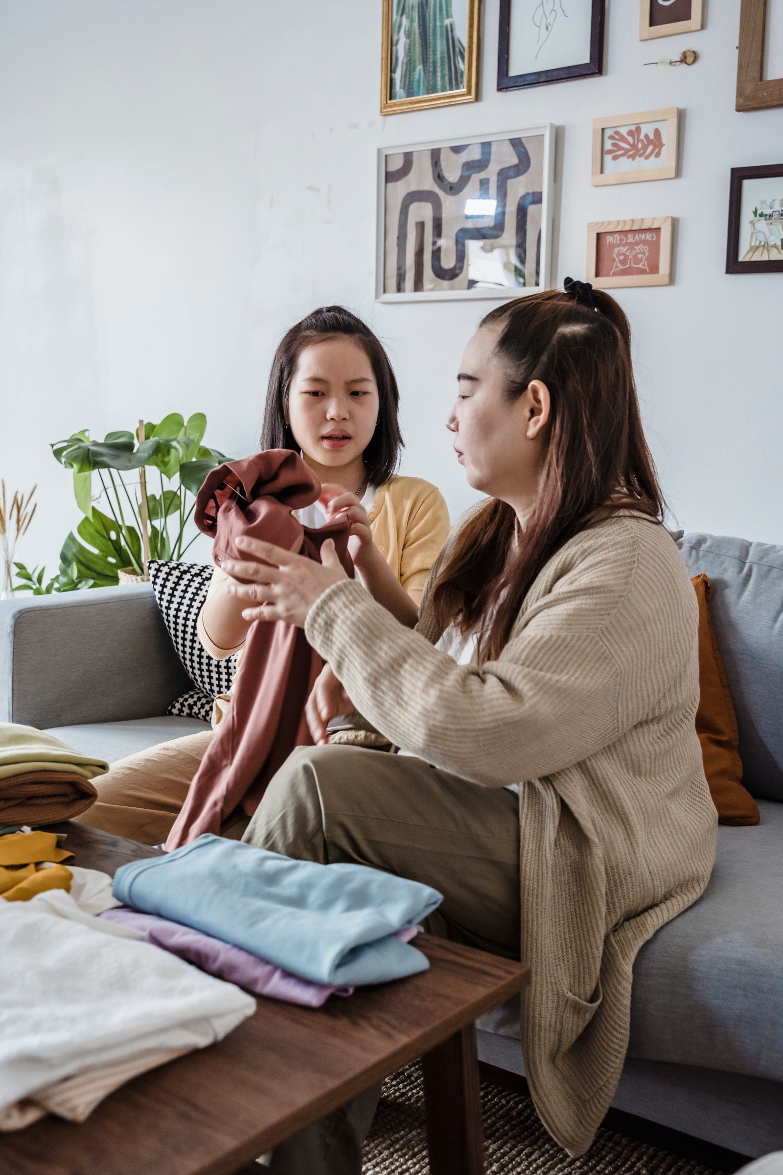 Mother and daughter holding and folding clean clothes