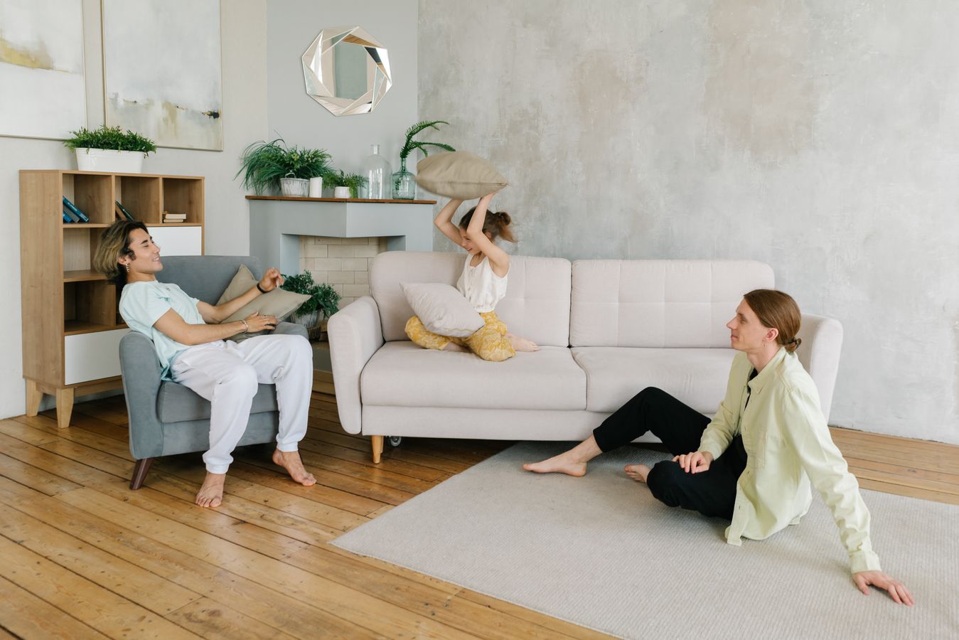 Family playing together in a bright living room with simple furniture and open floor space