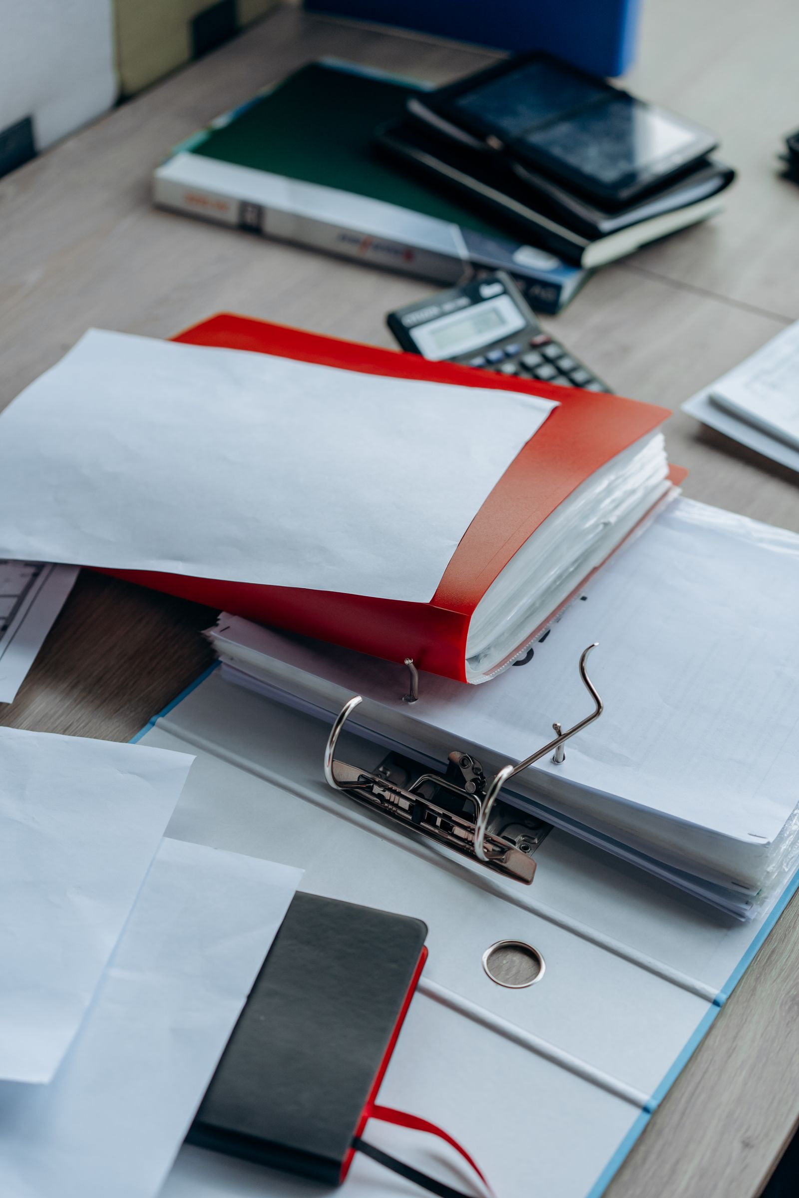 Documents, folders, and a phone on a desk