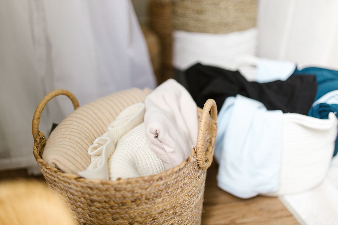 Children’s clothing organized in woven baskets in a small bedroom storage area