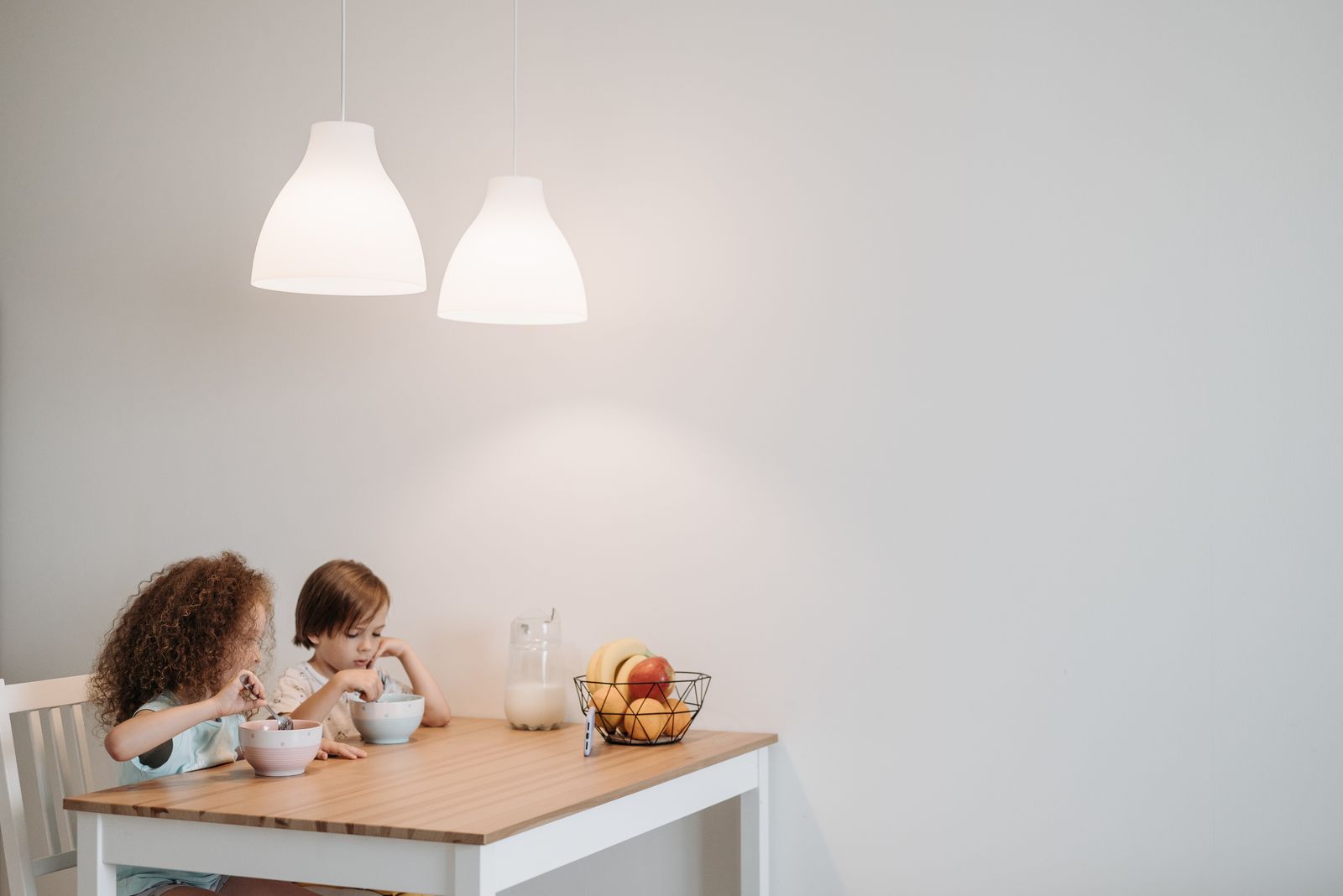 Two children eating at a small dining table