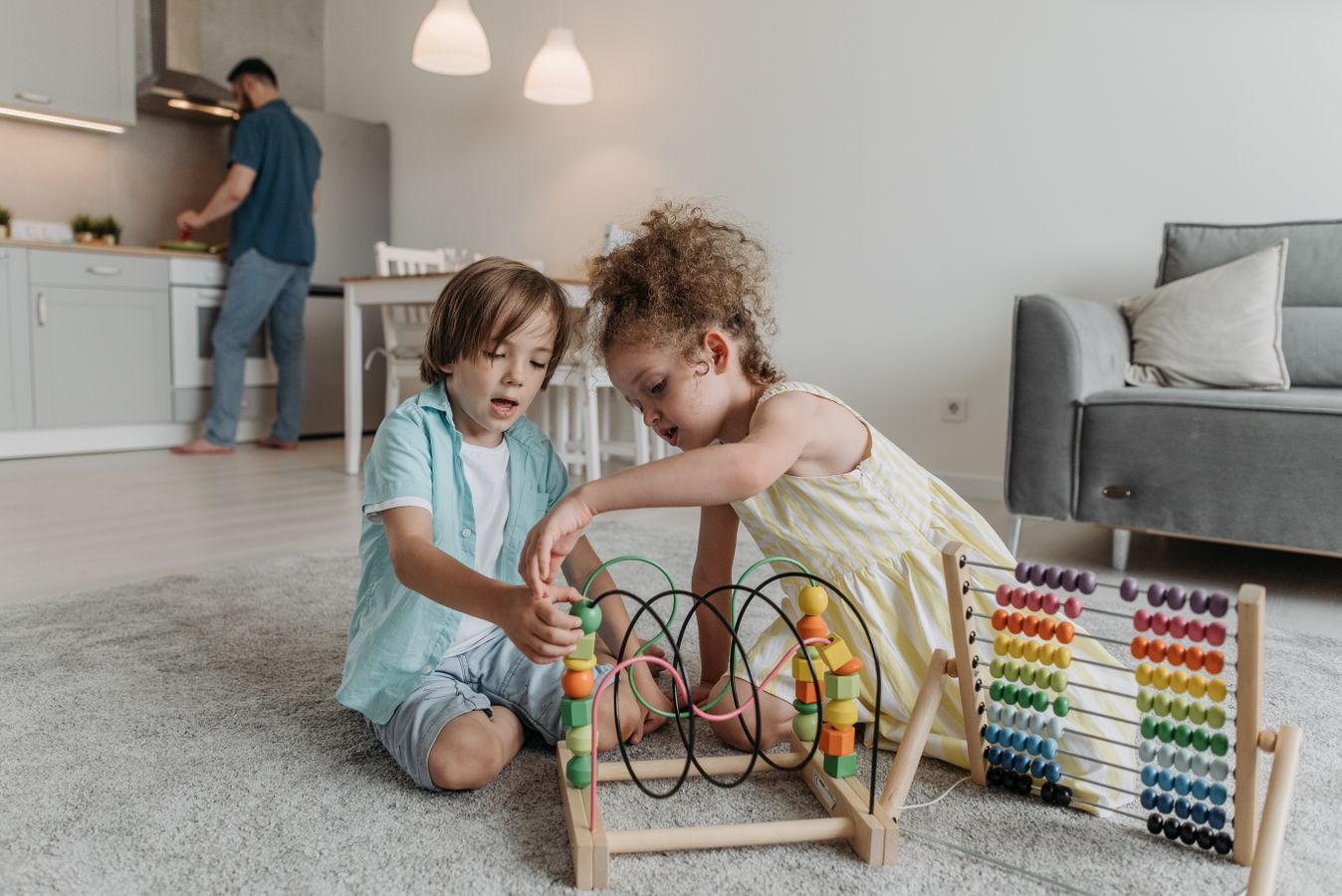 Two children playing on the floor in a living room with a clear path around the play area