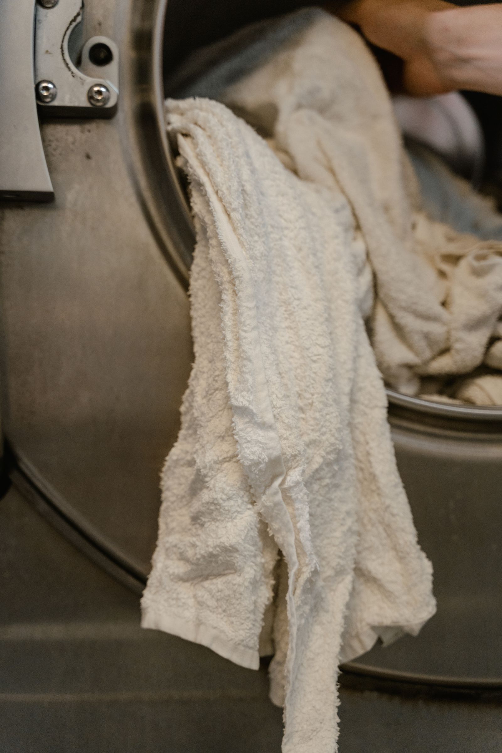 Clean towels being collected at a washing machine door
