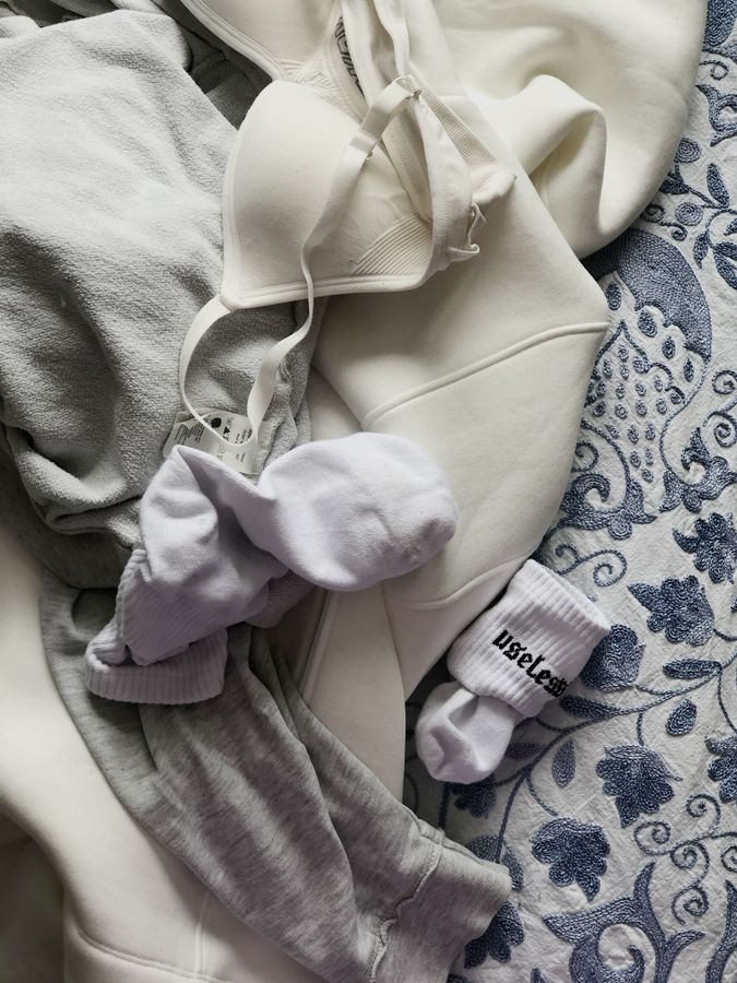 Pile of everyday clothes on a bed, illustrating how clothing can quickly make a small bedroom feel messy