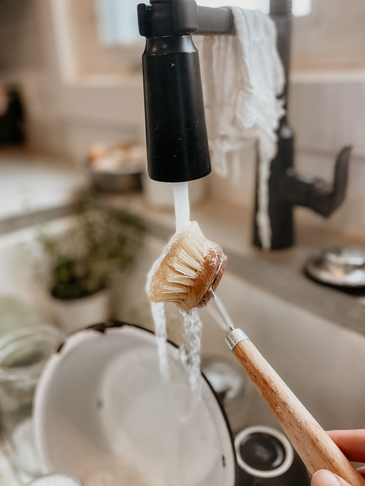 Cleaning brush held beneath a kitchen faucet