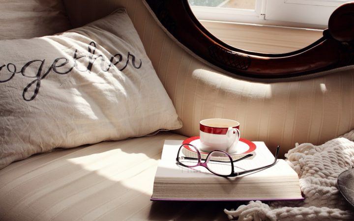 Book and glasses on a comfortable sofa for a small reading routine