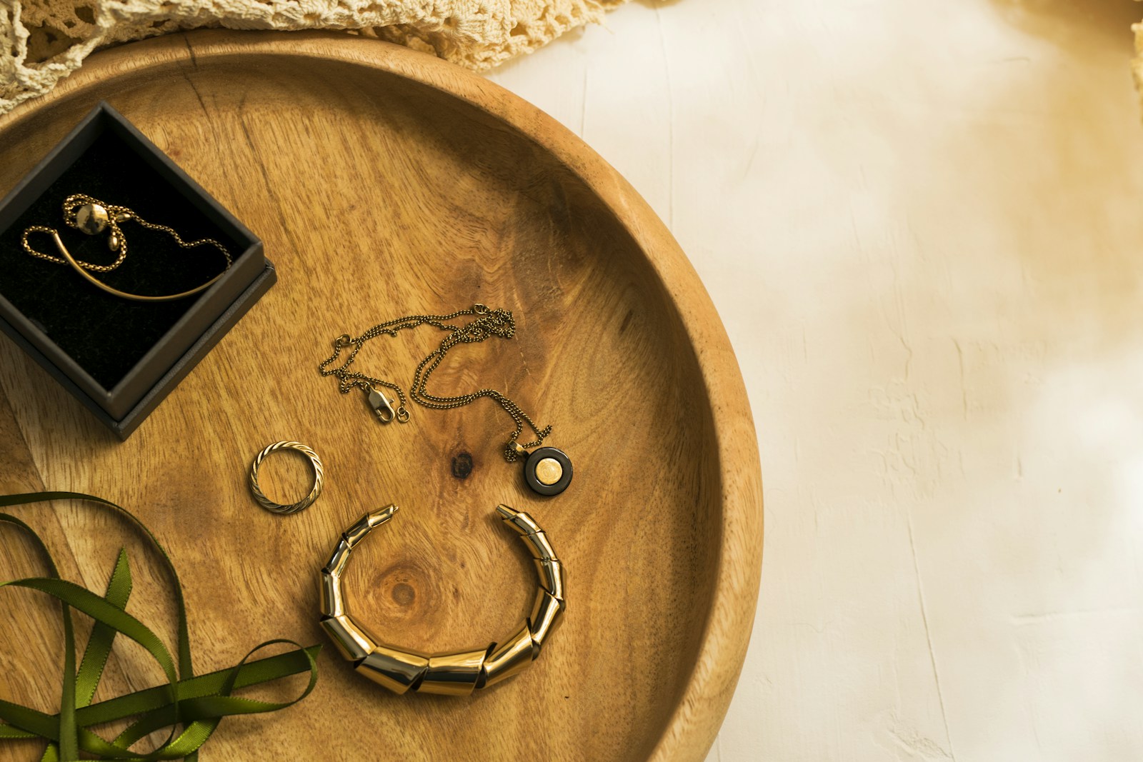 Jewelry and a small box on a round wooden tray