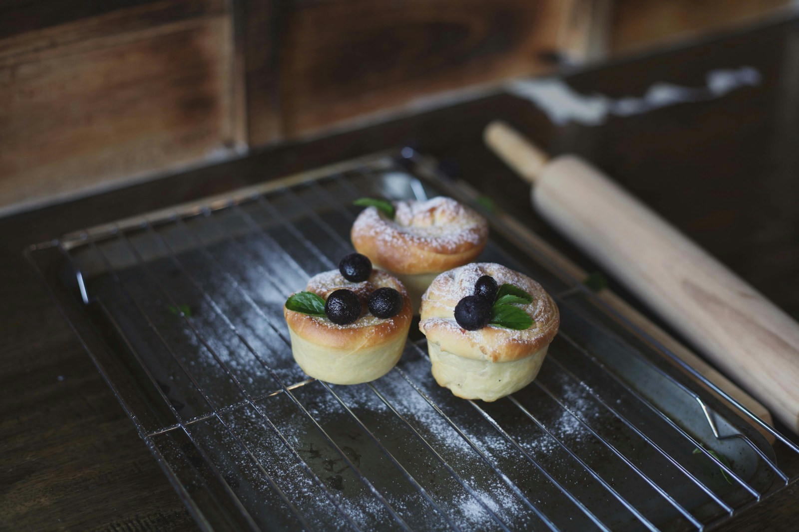 Small pastries on a baking tray beside a rolling pin