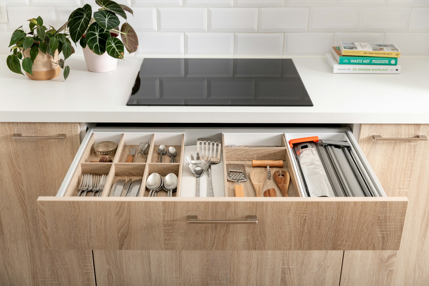 Shallow organized kitchen drawer demonstrating visible category boundaries