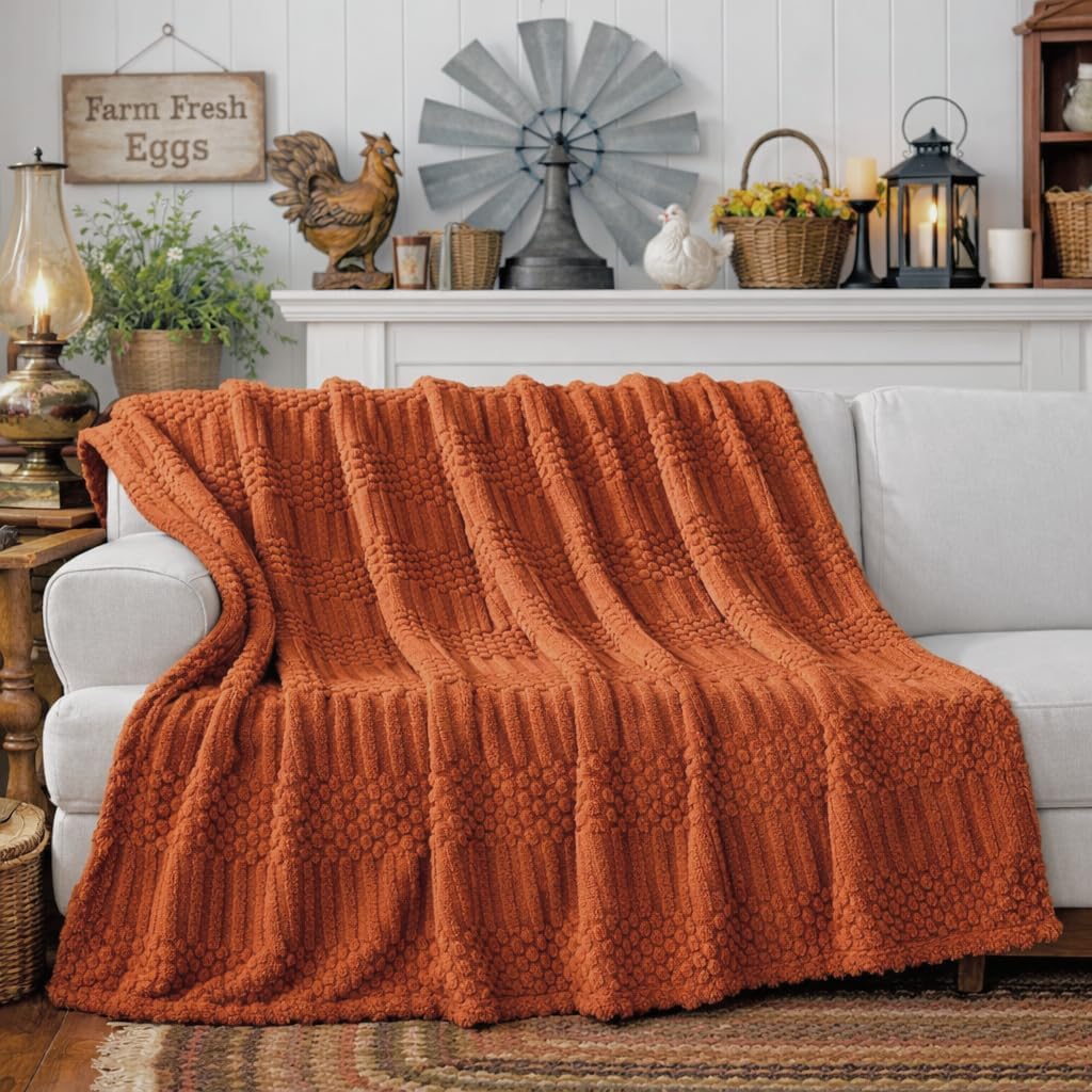 Rust throw draped over a sofa in a listing scene