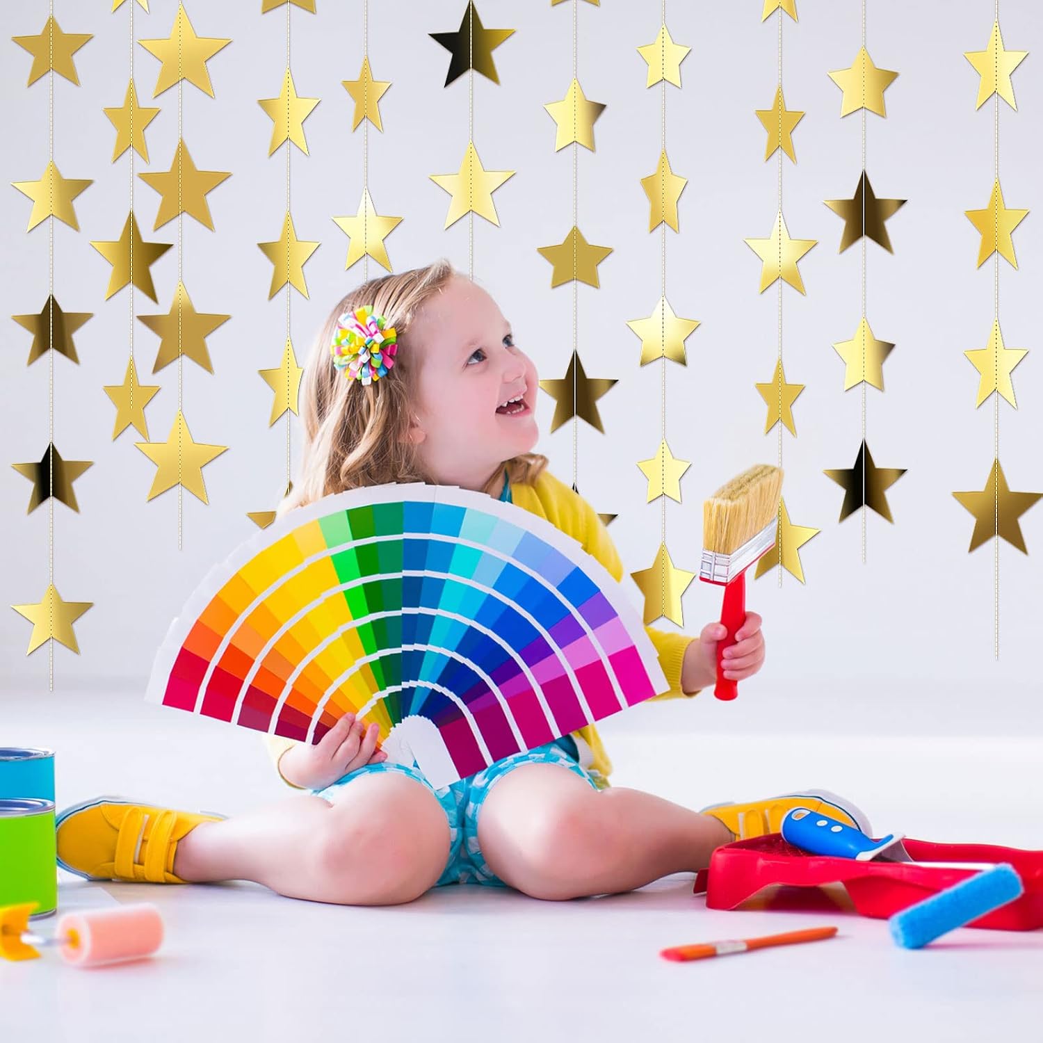 Supplier child party scene behind gold star garlands
